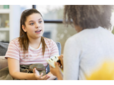 A teenage girl speaking with a counselor